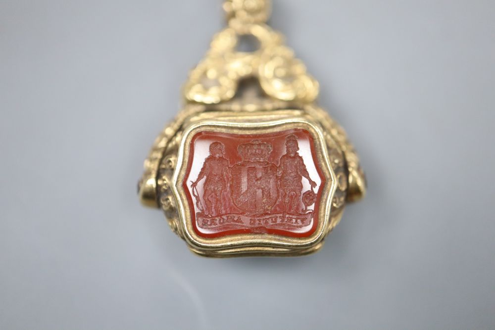 A Victorian yellow metal overlaid swivel triple gem set fob seal, with carved carnelian matrix, 37mm.